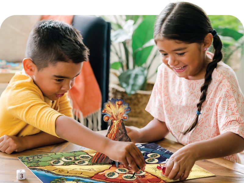 Two kids playing a cooperative volcano game